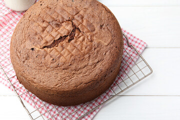 Tasty chocolate sponge cake on white wooden table, closeup