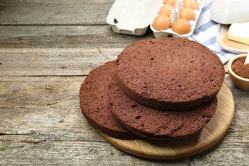 Cut chocolate sponge cake and ingredients on wooden table. Space for text