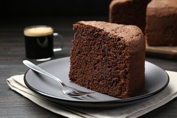 Piece of tasty chocolate sponge cake served on wooden table, closeup