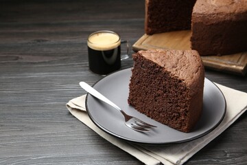 Piece of tasty chocolate sponge cake served on wooden table, closeup