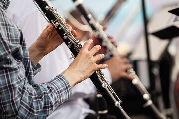 Hands of man playing the clarinet in the orchestra