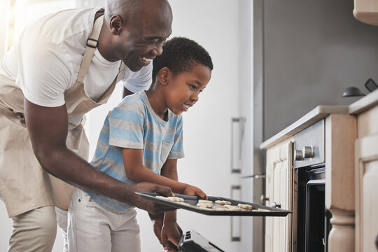 Baking, cooking in oven and father with son in kitchen of home together for child development. Help, love and smile of black family in apartment with single parent man teaching boy child how to bake
