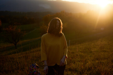 Fototapeta premium a portrait young woman in mustard sweater in autumn mountains at sunset