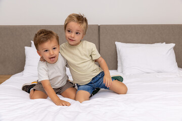 Brothers playing on bed in bedroom