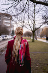 portrait of a stylish middle-aged woman with braids on a spring street