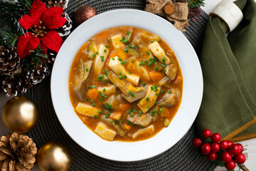 Squid stew with potatoes, artichokes and vegetables. Top view table with christmas decoration.