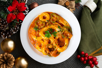 Squid stew with potatoes, artichokes and vegetables. Top view table with christmas decoration.