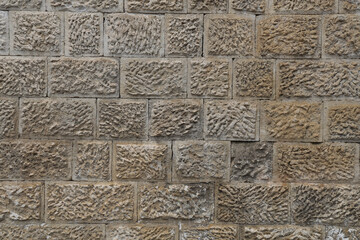yellow brown stone texture tile pattern - tiled background. Old gray stone wall, backdrop. Natural stone wall from small square parts. beige Background for interior exterior.