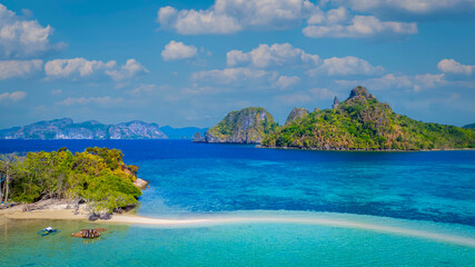 Aerail view of  tropical exotic island sand bar separating sea in two with turquoise  in El Nido, Palawan, Philippines.