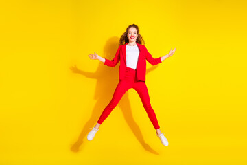 Fototapeta na wymiar Full size photo of pretty young woman jump wear red suit isolated on yellow color background