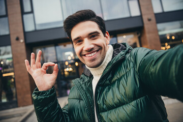Photo of young positive attractive man dressed trendy clothes recording video blog live streaming...