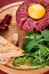 Tartar with egg and arugula. fresh ground meat with seasonings. fresh greens.