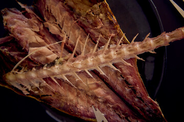 the  process of dissecting hot smoked golden horse mackerel with small knives