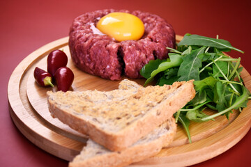 Tartar with egg and arugula. fresh ground meat with seasonings. fresh greens.