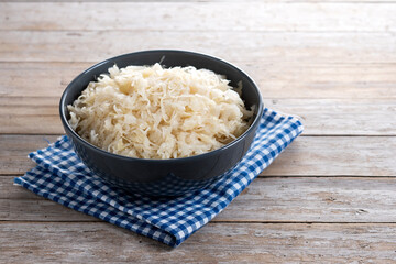 Sauerkraut in a bowl on wooden table. Traditional german food. Copy space
