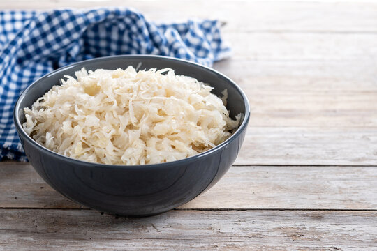 Sauerkraut in a bowl on wooden table. Traditional german food. Copy space