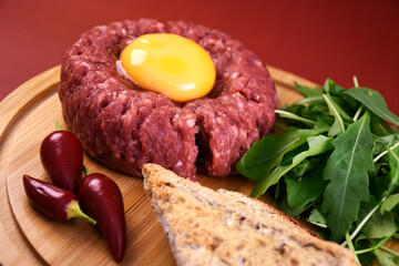 Tartar with egg and arugula. fresh ground meat with seasonings. fresh greens.