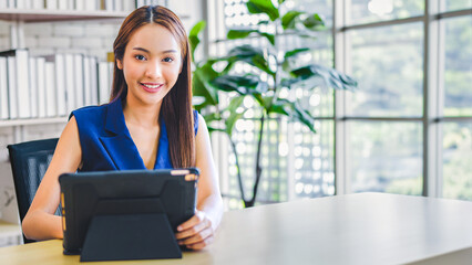 Attractive young Asian Business woman presenting and discussing financial data and analyzing report graph by digital tablet at office. Teamwork meeting and partnership conference working concept.	
