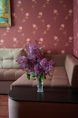 a bouquet of lilacs in a crystal vase in the interior