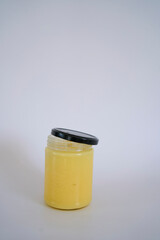        butter ghee in a transparent jar with homemade bread on a white background