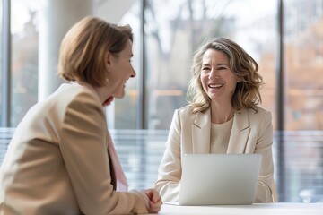Two Professional Women Engaged in a Friendly Business Conversation in a Modern Office Setting