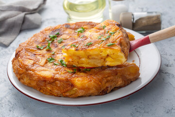 Spanish omelette with potatoes, typical spanish cuisine on gray concrete floor. Tortilla Espanola. Turkish name; Yumurtali patates