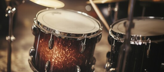 Obraz premium drum kit with a focus on one drum, such as a snare drum, set against a plain background to showcase its texture and details. 