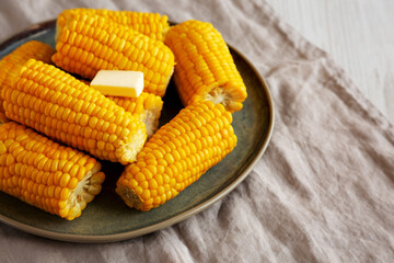 Homemade Organic Steamed Yellow Sweet Corn on the Cob with Butter, side view. Copy space.