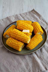 Homemade Organic Steamed Yellow Sweet Corn on the Cob with Butter, side view.