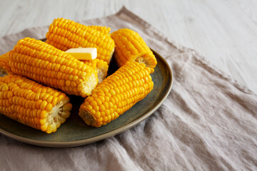 Homemade Organic Steamed Yellow Sweet Corn on the Cob with Butter, side view.