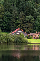 Obraz premium Chalet et habitation au bord d'un lac de montagne à Retournemer dans les Vosges