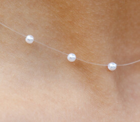 Close-up of pearl beads on a girl's neck. Macro