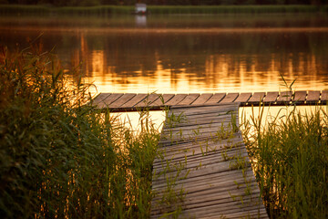 Wooden bridge on the lake at sunset