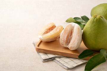 Fresh pomelo fruit with leaf on white table background.