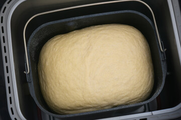 Close up photograph of a baking loaf of white bread in a bread maker machine. 