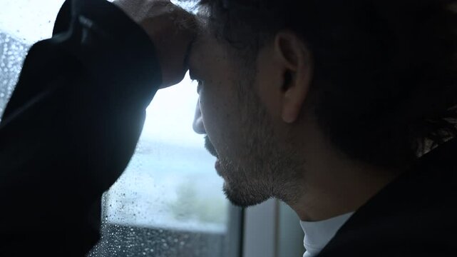 窓の外を見つめて仕事やストレスで悩む中年男性の転職や退職などの孤独なネガティブイメージの動画　窓をたたく音あり