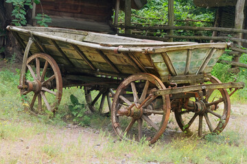 Fototapeta premium Antique wooden cart. Rustic transport in nature landscape.