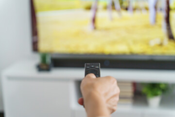 Elderly woman Watching smart TV and using remote controller Hand holding television audio remote control Middle age Asian woman movie Television series spending time at home