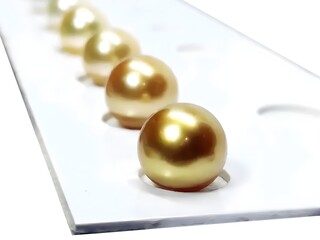 Golden Pearls on a White Background Display