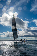 dynamisches Gegenlichtfoto mit Segelyacht und Wassertropfen auf der Linse