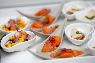 Salmon appetizers being served on a white tray during a catered event