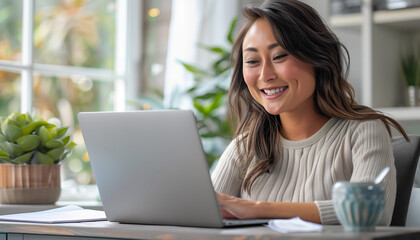 Fototapeta premium Smiling professional woman working on laptop in bright office environment with natural light and greenery for business presentation or marketing campaign featuring healthy lifestyle and modern technol