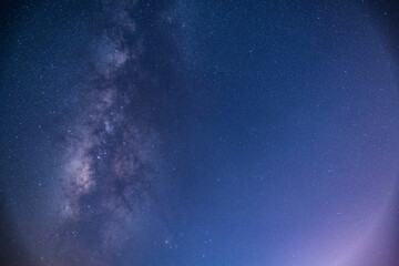 Fototapeta premium A breathtaking view of the Milky Way stretching across the night sky above a calm sea. The starry band of our galaxy is visible in all its glory. Suao, Yilan County, Taiwan.