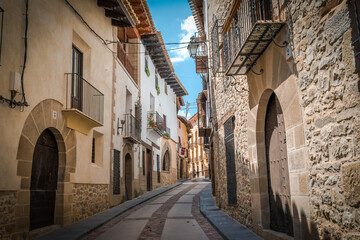 Detail of a medieval cobblestone street with blue sky in Spain.