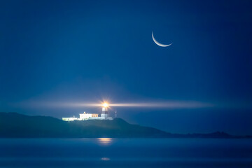 A crescent moon illuminates a serene night seascape, casting its gentle glow over a lighthouse...
