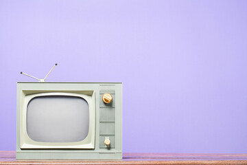 Retro old TV on table front purple background. Vintage style filtered photo