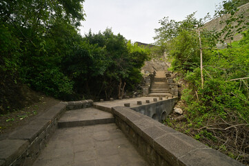 Man made stone stairway amidst lush green forest ascending from Lonar crater situated in Maharashtra, India.