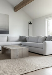 Modern living room with gray sectional sofa and minimalist decor in a bright, airy space