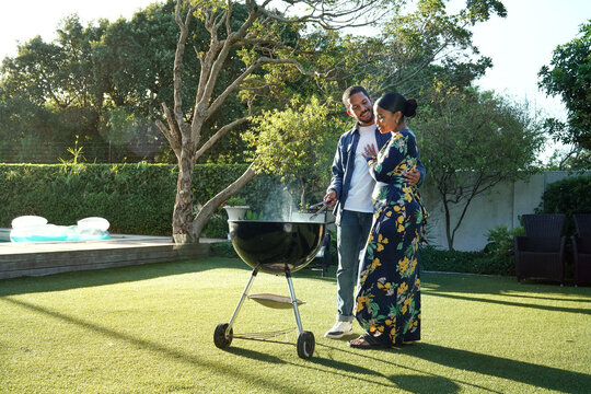 Couple at barbecue grill in garden
