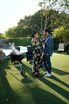 Couple at barbecue grill in garden